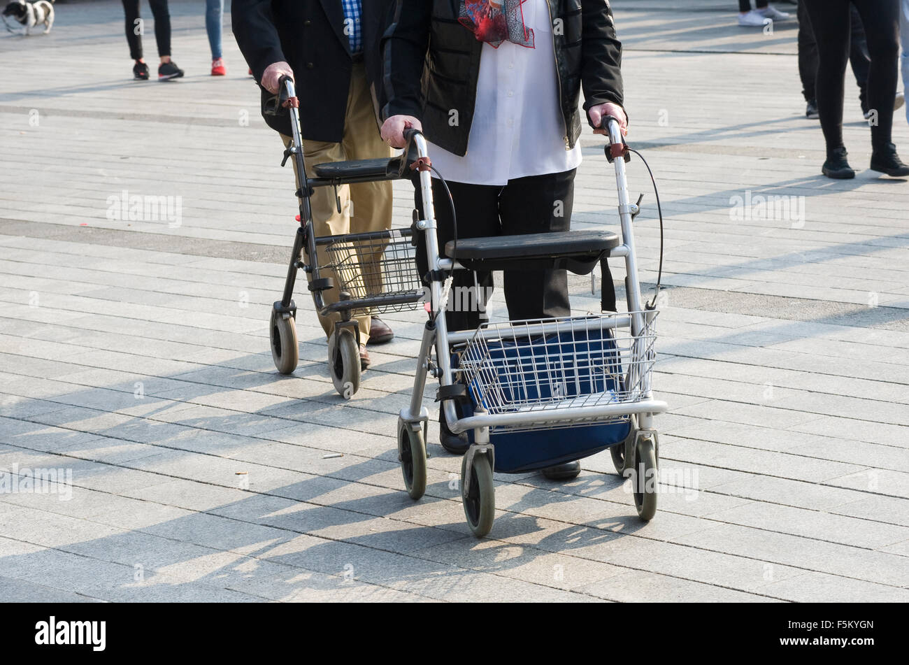 Un couple de personnes âgées est de marcher dans la rue avec leurs cadres de marche Banque D'Images