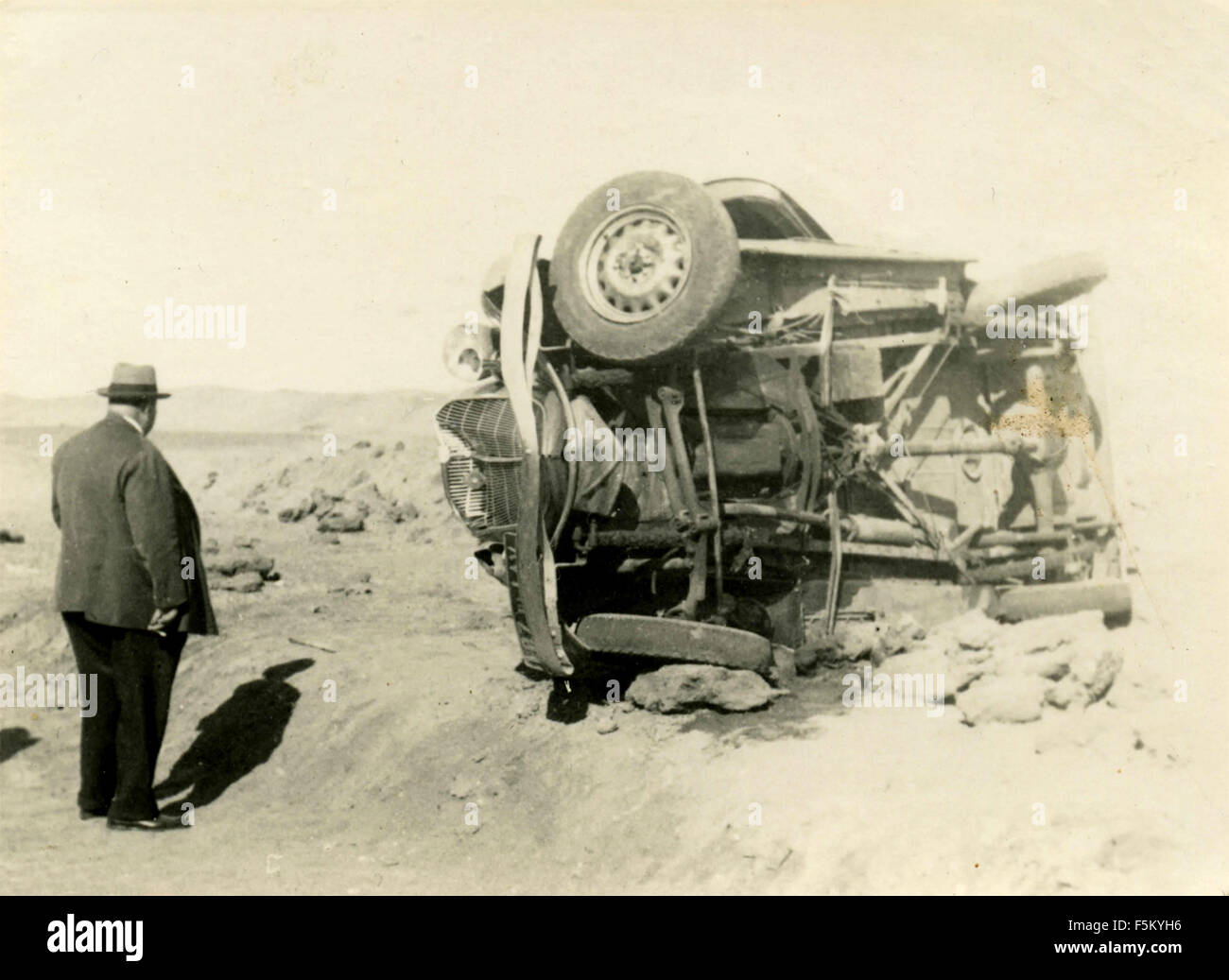 Un homme observe une voiture renversée, Italie Banque D'Images