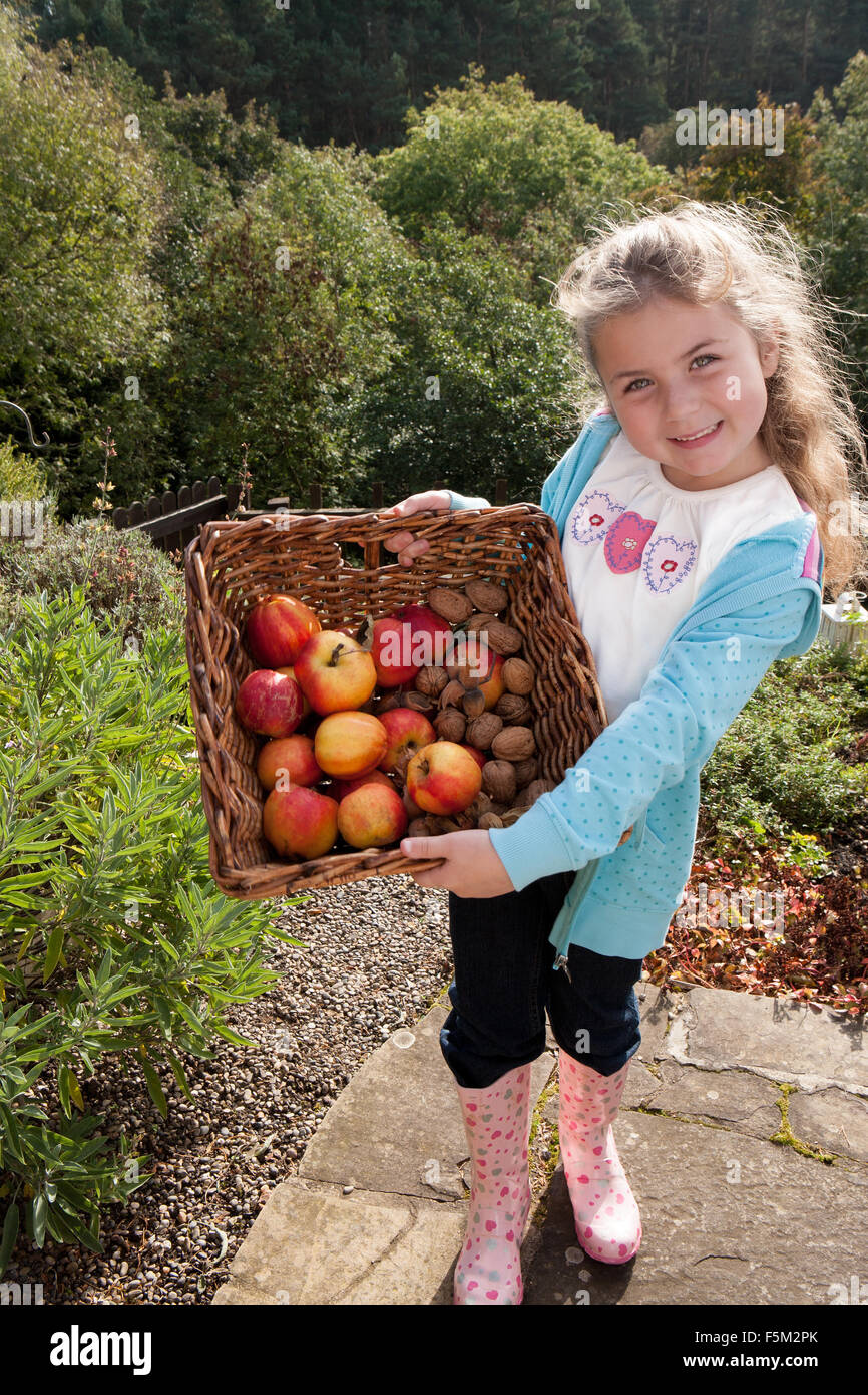 Jeune fille posant avec un panier de fruits cueillis à la main Banque D'Images