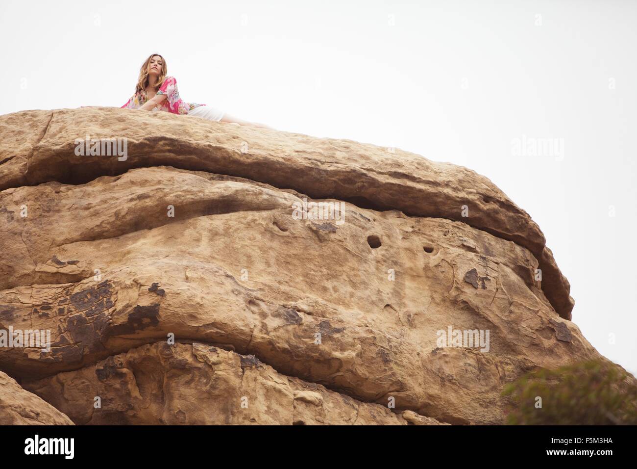 Woman relaxing on rock formation, Stoney Point, Topanga Canyon, Chatsworth, Los Angeles, Californie, USA Banque D'Images