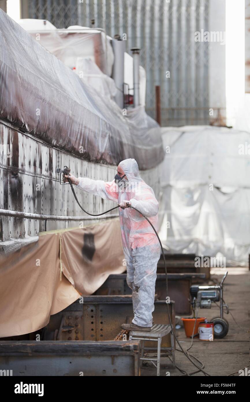 Peinture par pulvérisation des travailleurs du chantier naval en bateau Banque D'Images