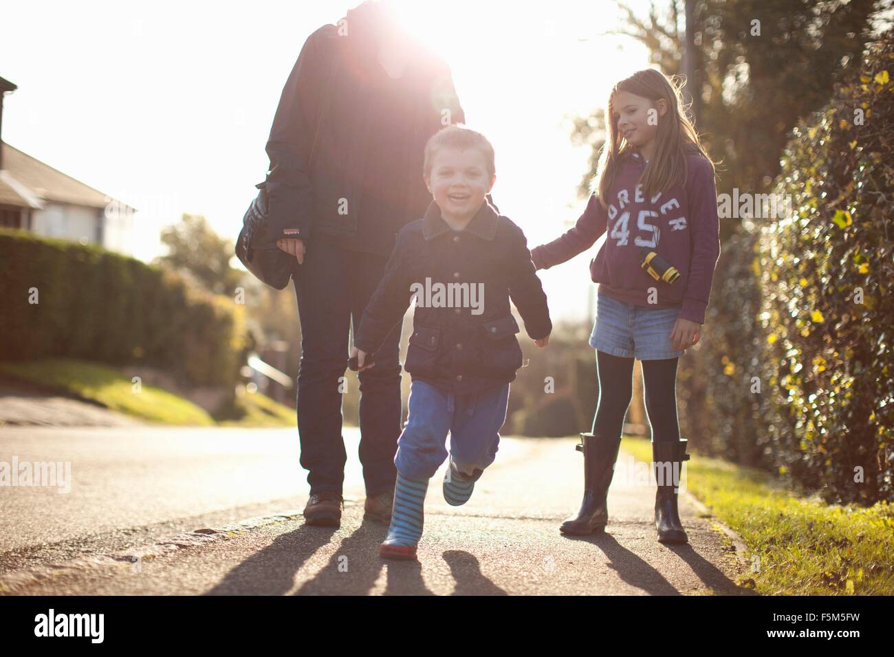 La mère et deux enfants de marcher le long de routes de campagne Banque D'Images