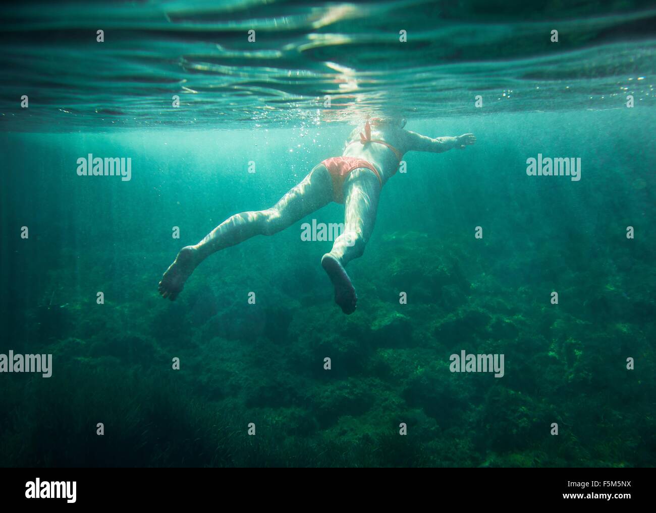 Underwater view of mid adult woman swimming, Minorque, Iles Baléares, Espagne Banque D'Images
