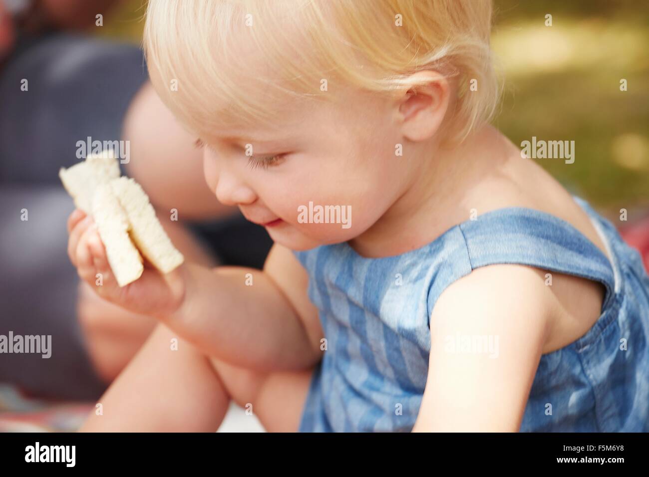Portrait of baby girl holding à sandwich Banque D'Images