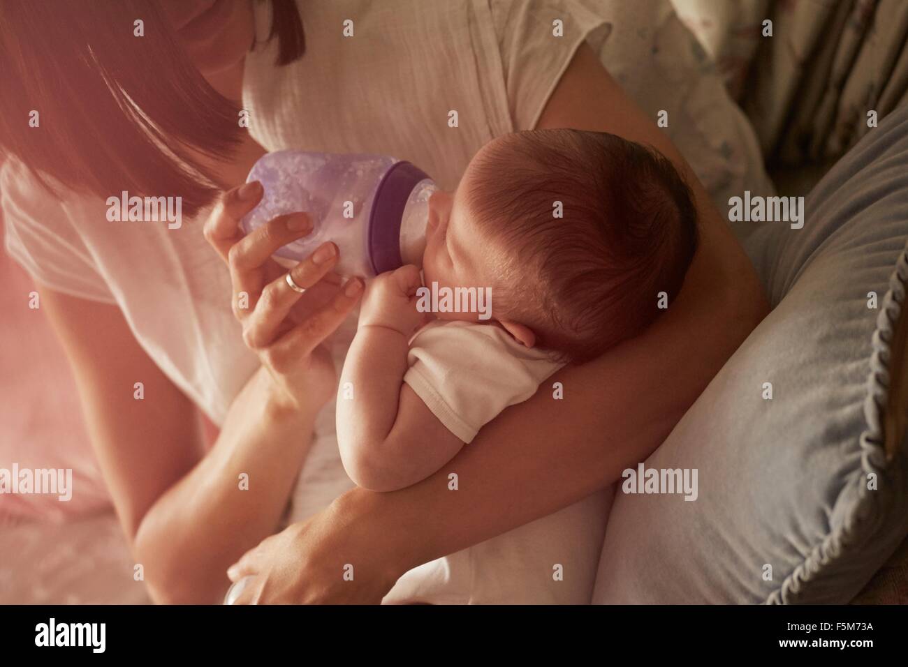 Mère nourrir bébé dans les bras Banque D'Images