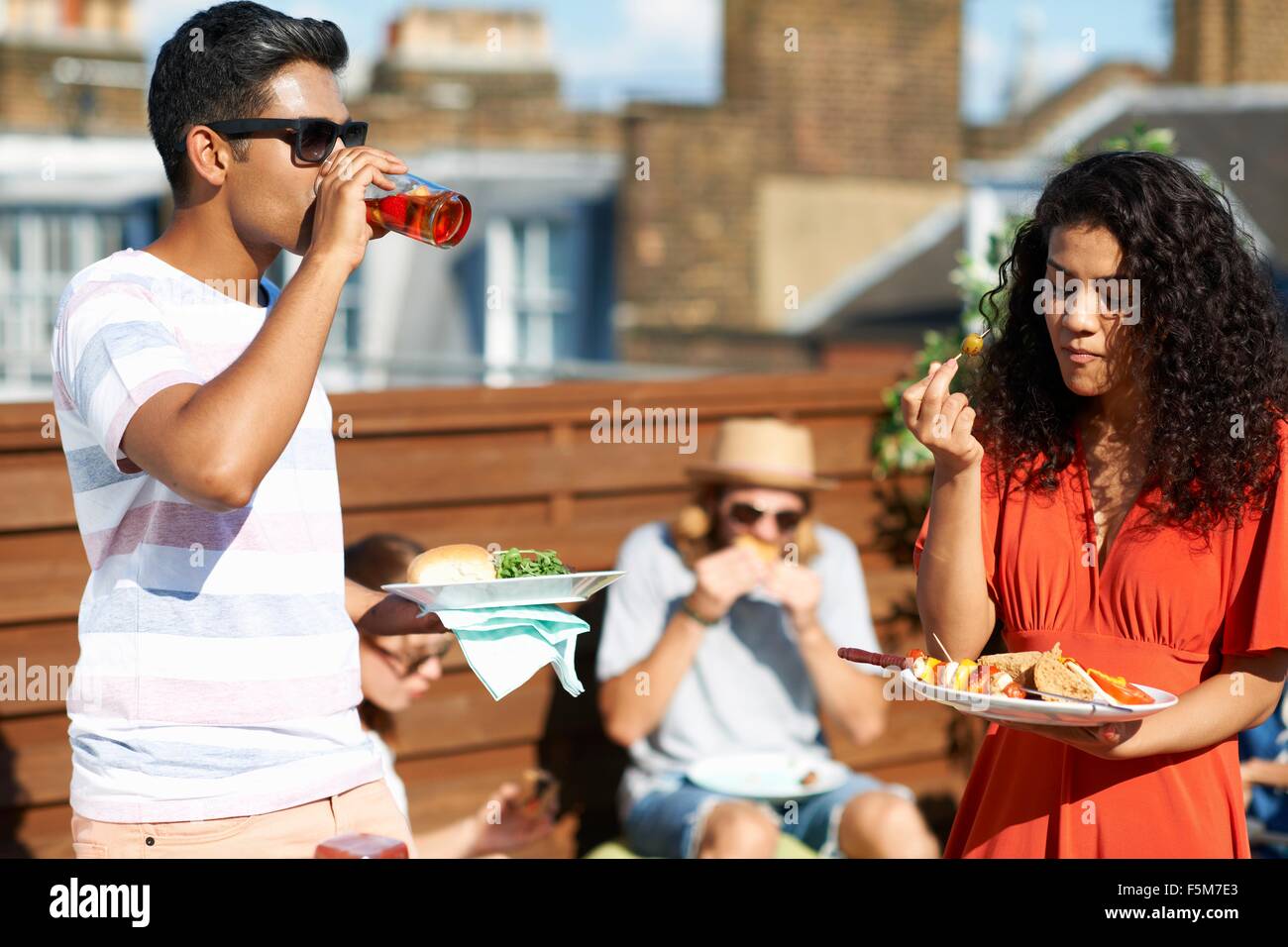 Les amis de manger et boire des aliments partie at rooftop party Banque D'Images Les amis de manger et boire des aliments partie at rooftop party Banque D'Images