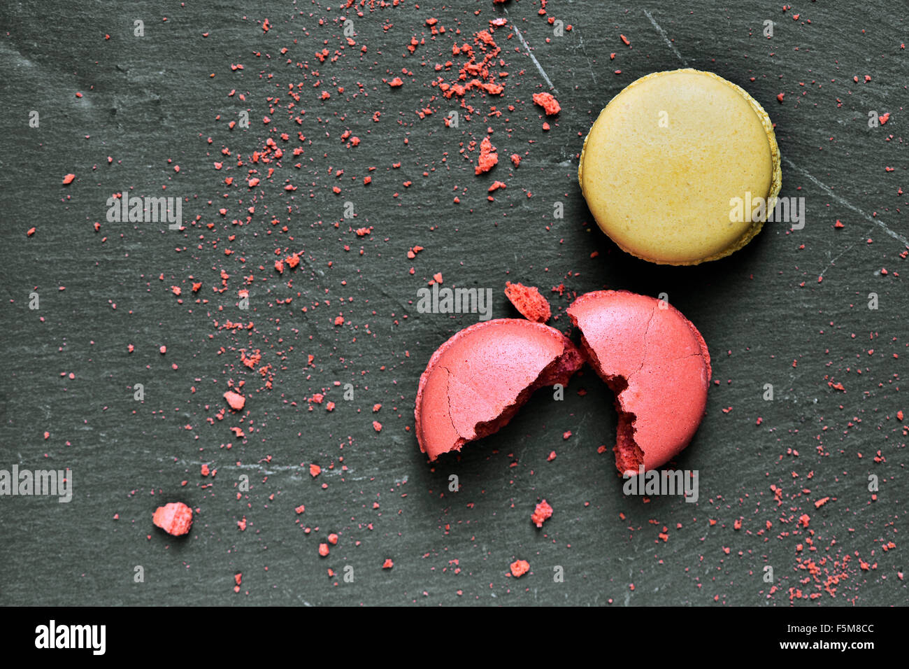 Certains macarons appétissants de saveurs différentes sur une surface en ardoise Banque D'Images