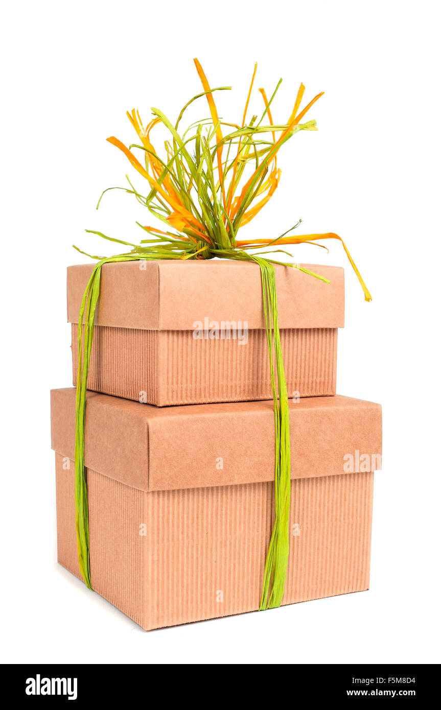 Quelques cadeaux en carton brun attaché avec du raphia naturel de différentes couleurs sur un fond blanc Banque D'Images