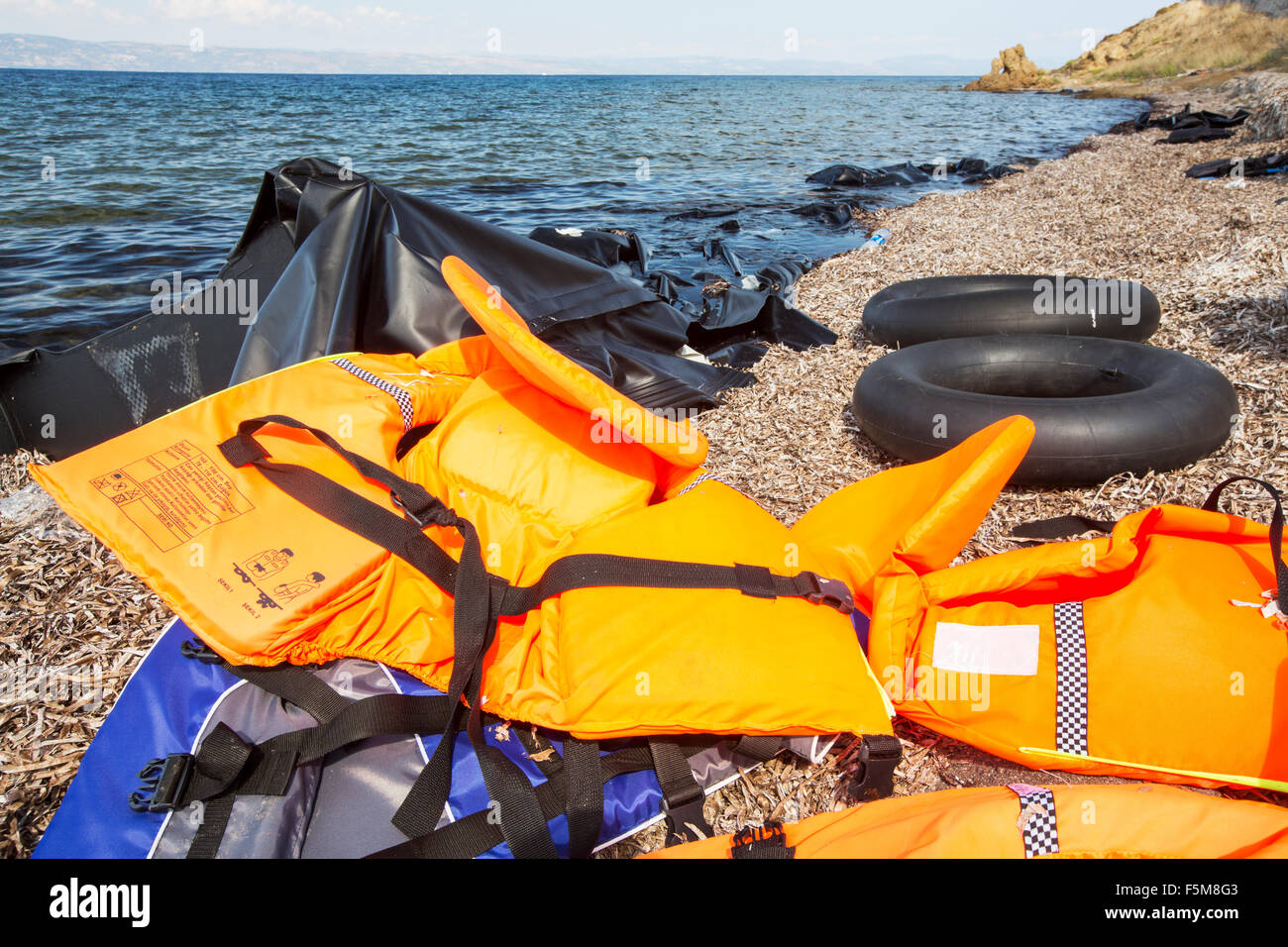 Les gilets et les restes de bateaux laissés par des migrants syriens fuyant la guerre et la fuite vers l'Europe, de l'atterrissage sur l'île grecque de Lesbos, sur la côte nord à Efthalou. Jusqu'à 4 000 migrants par jour sont l'atterrissage sur l'île et écrasante les autorités. Ils sont traficked illégale par les trafiquants qui peuple turc frais jusqu'à 2 000 $ par personne pour un trajet d'une demi-heure dans un logement surpeuplé inflateable bateau de la Turquie continentale à Lesvos. Banque D'Images