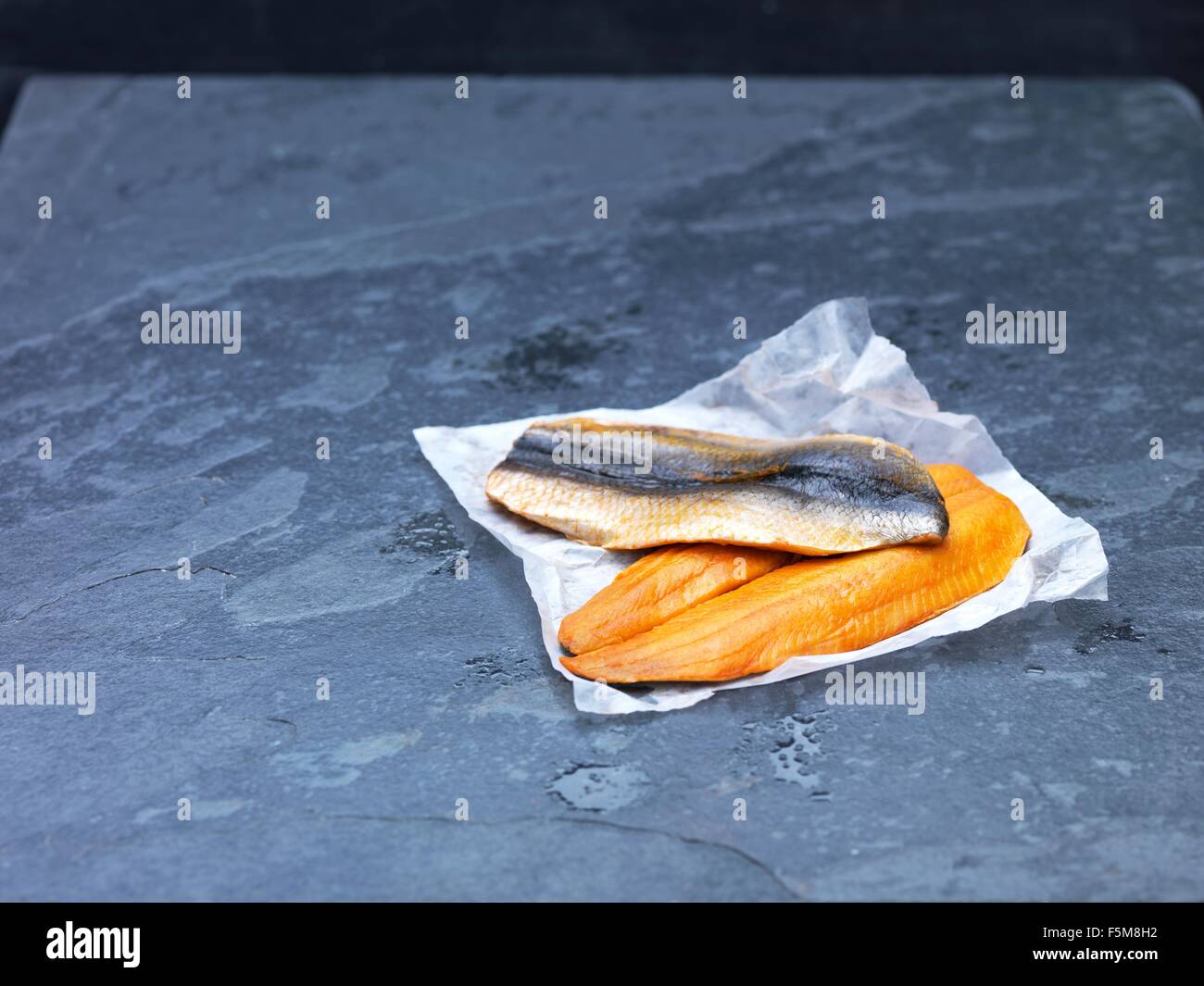 Portrait de matières Scottish kipper filets sur du papier sulfurisé et l'ardoise Banque D'Images