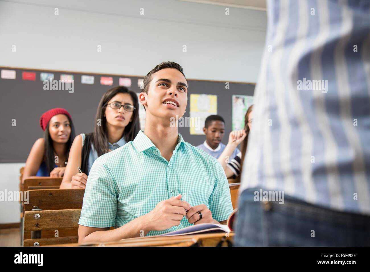 Male student talking to teacher in classroom Banque D'Images