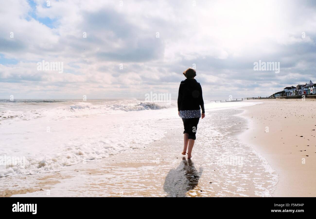 Femme mature, marcher le long de la plage, vue arrière Banque D'Images
