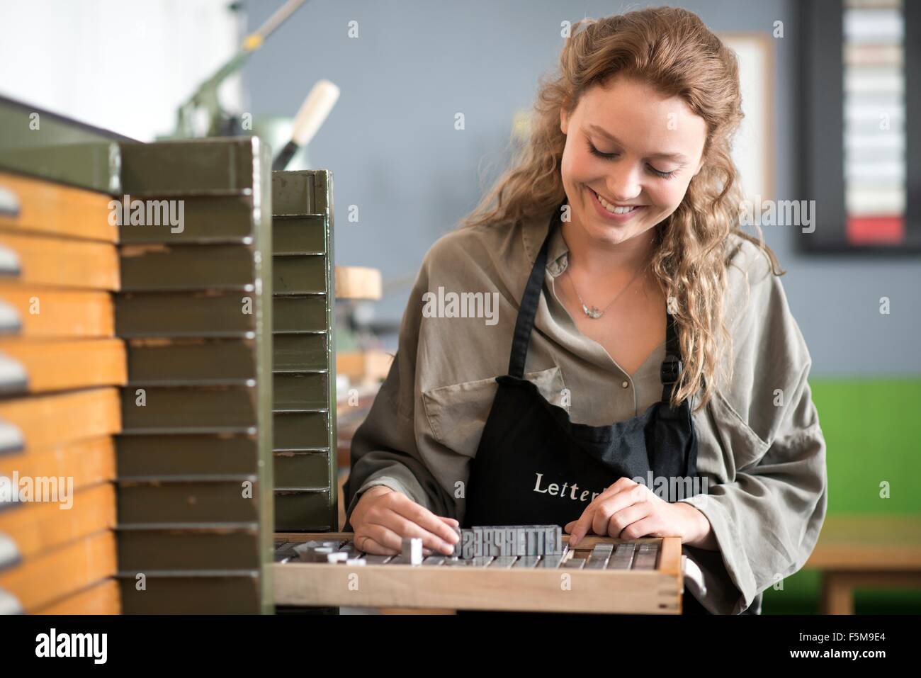 Femme avec bac d'impression typographique en atelier Banque D'Images