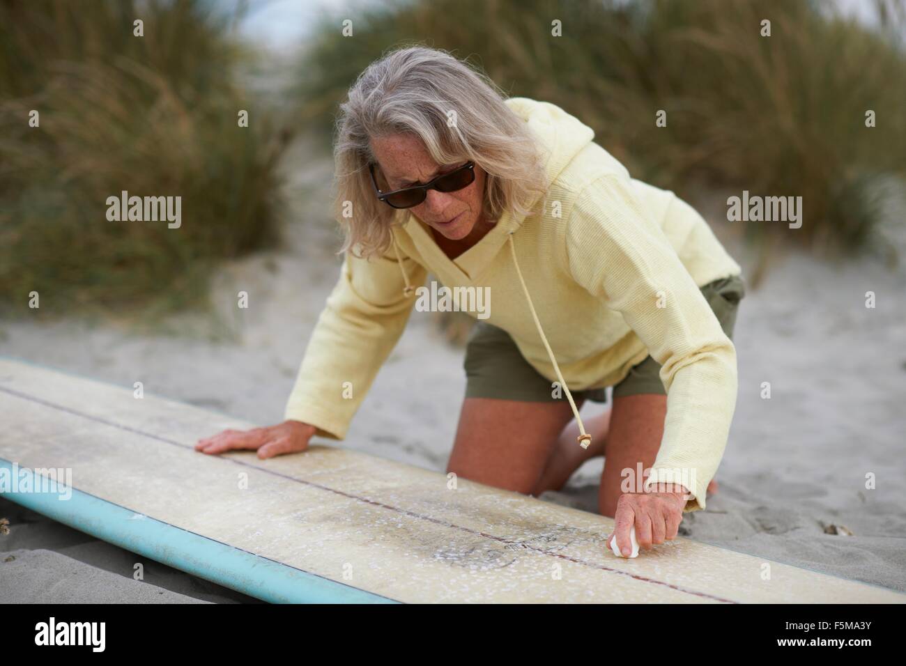 Senior woman on beach, fartage de surf Banque D'Images