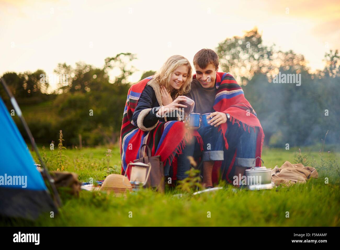 Les jeunes camping couple drinking tea Banque D'Images