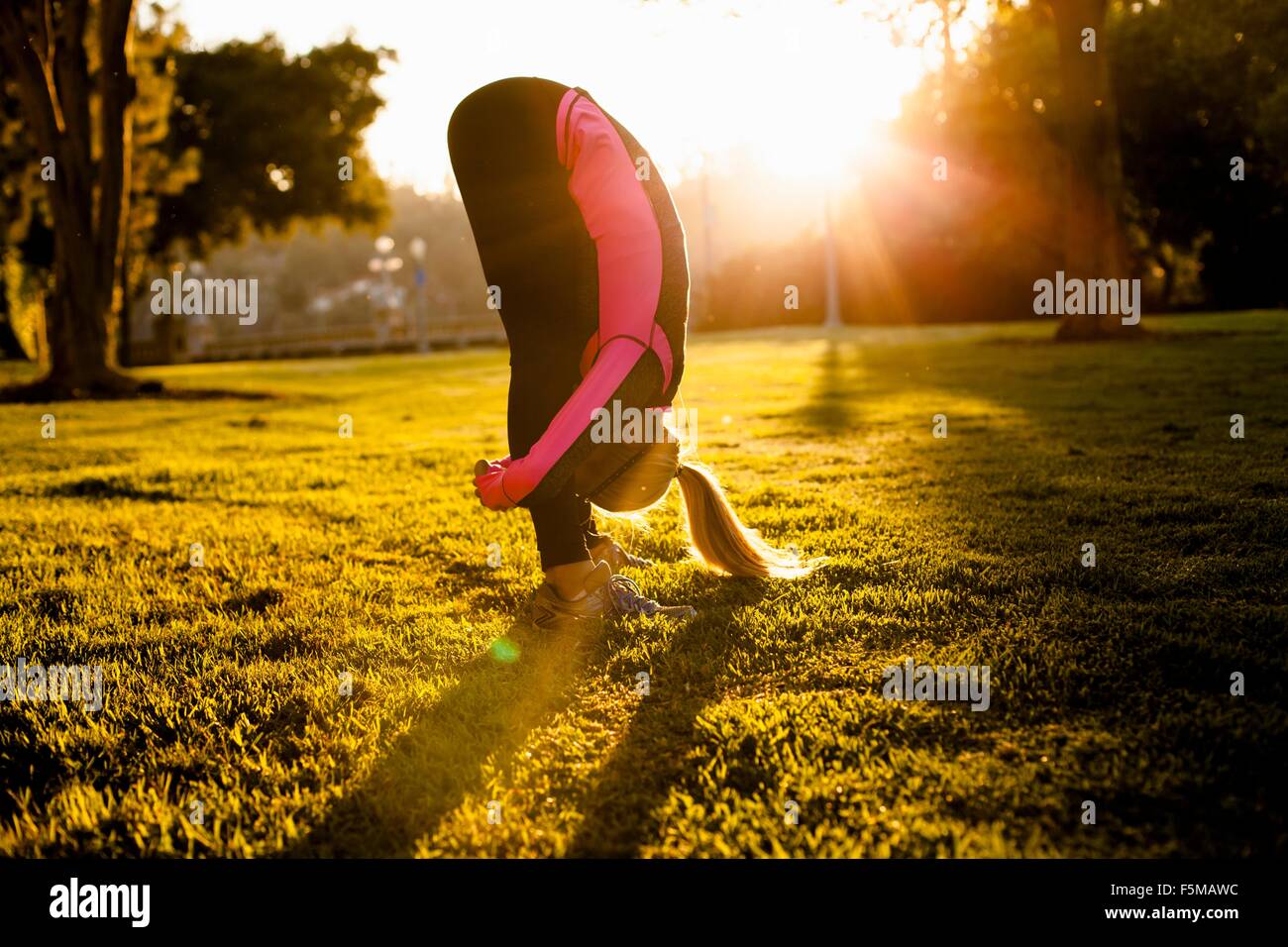 Woman stretching in park Banque D'Images