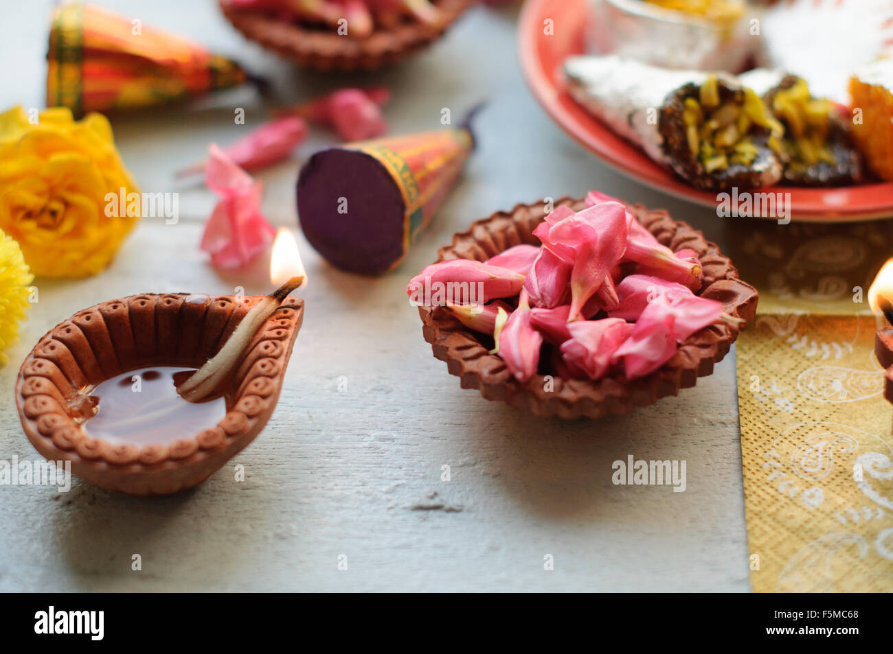 Diyas Diwali sur un fond de bois avec des fleurs et des lumières de fête Banque D'Images