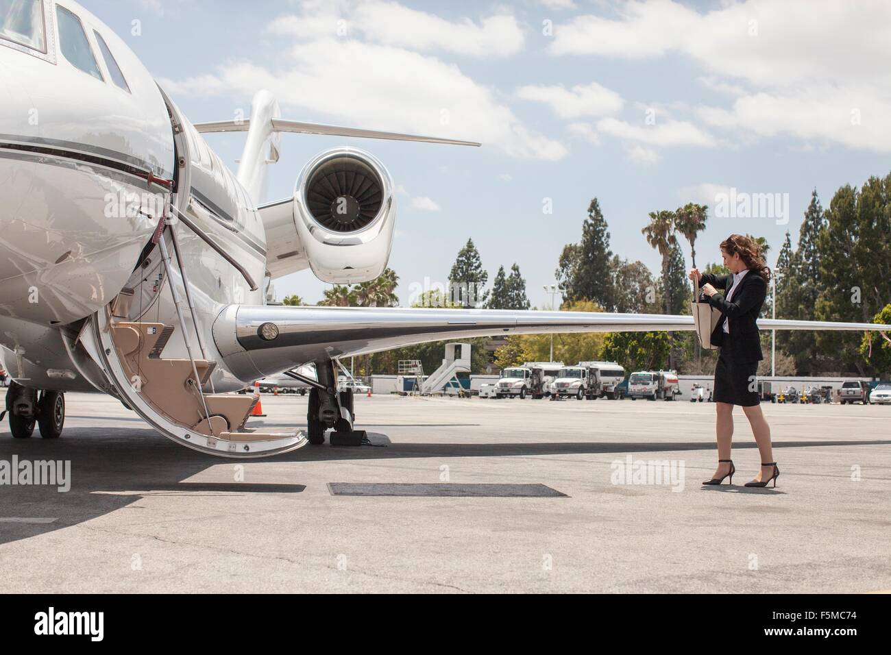 Femme femme prépare à bord jet privé à l'aéroport Banque D'Images