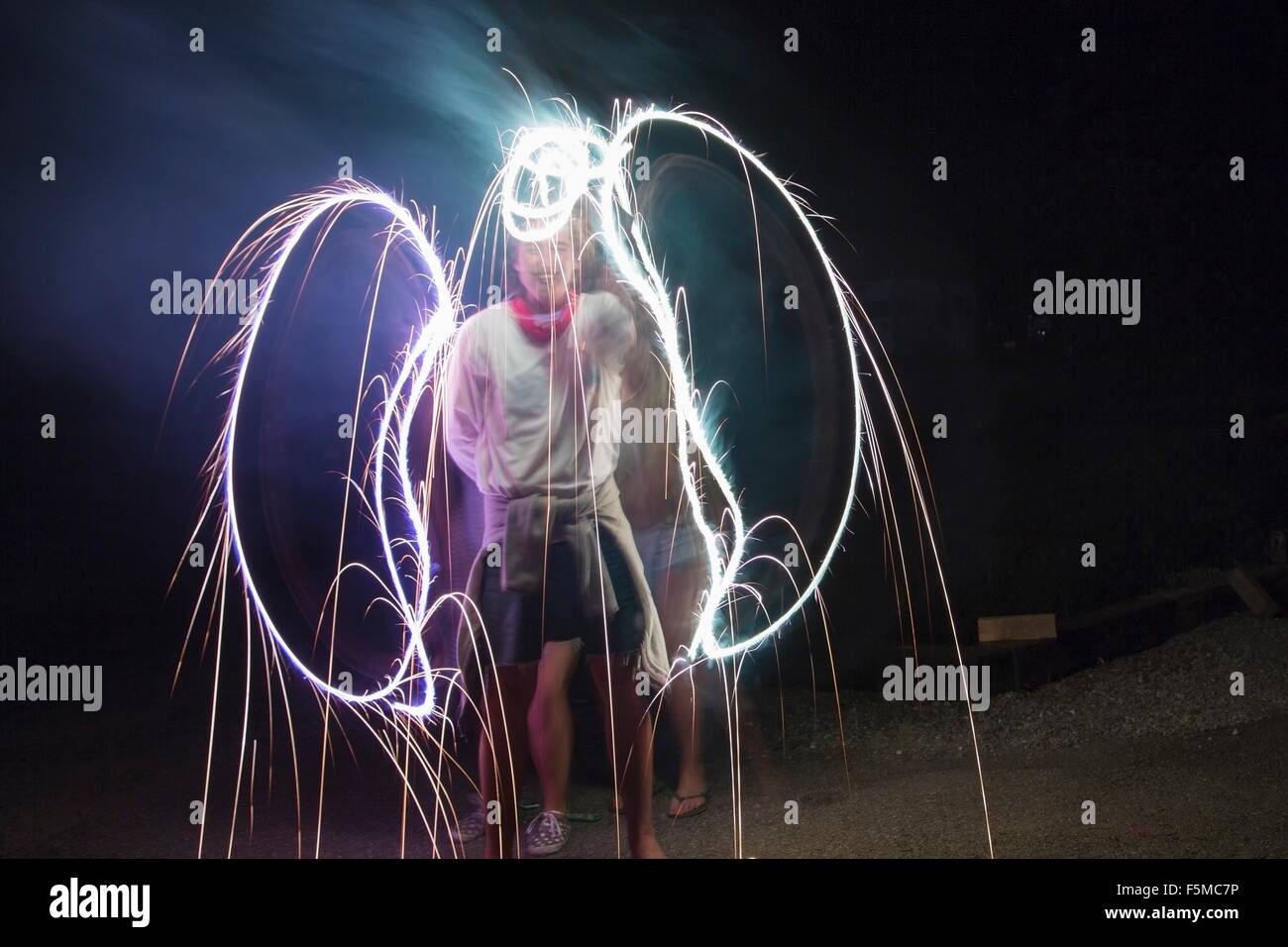 Deux amis adultes faisant sparkler angel wings dans l'obscurité le jour de l'indépendance, USA Banque D'Images