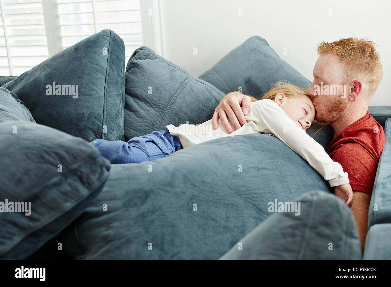 Père et fille couchée sur pile de coussins dans la salle de séjour Banque D'Images