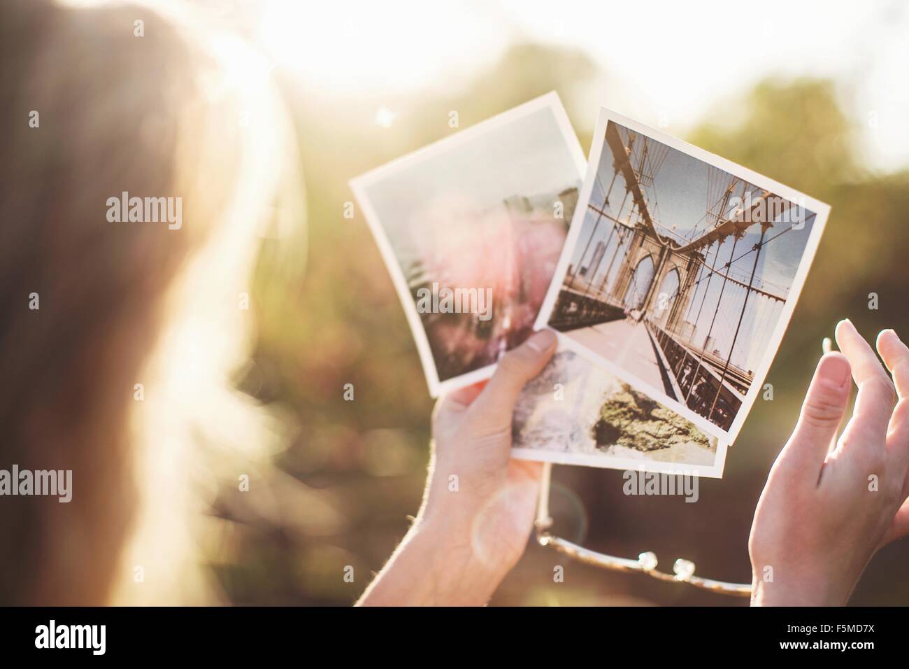 High angle view over Shoulder of young woman holding photographies Banque D'Images