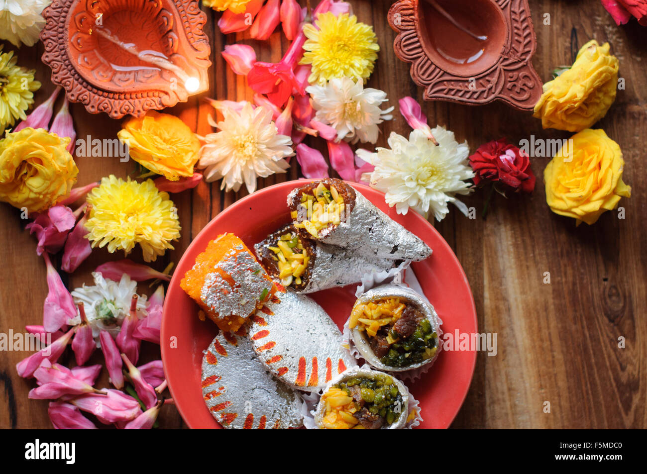 Diyas Diwali sur un fond de bois avec des fleurs et des lumières de fête Banque D'Images