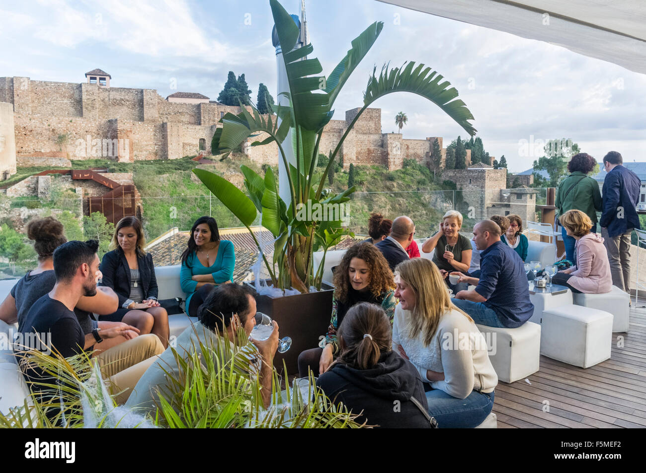 Les gens au bar sur le toit-terrasse et le château Maure Alcazaba en arrière-plan. Malaga, Andalousie, Espagne Banque D'Images