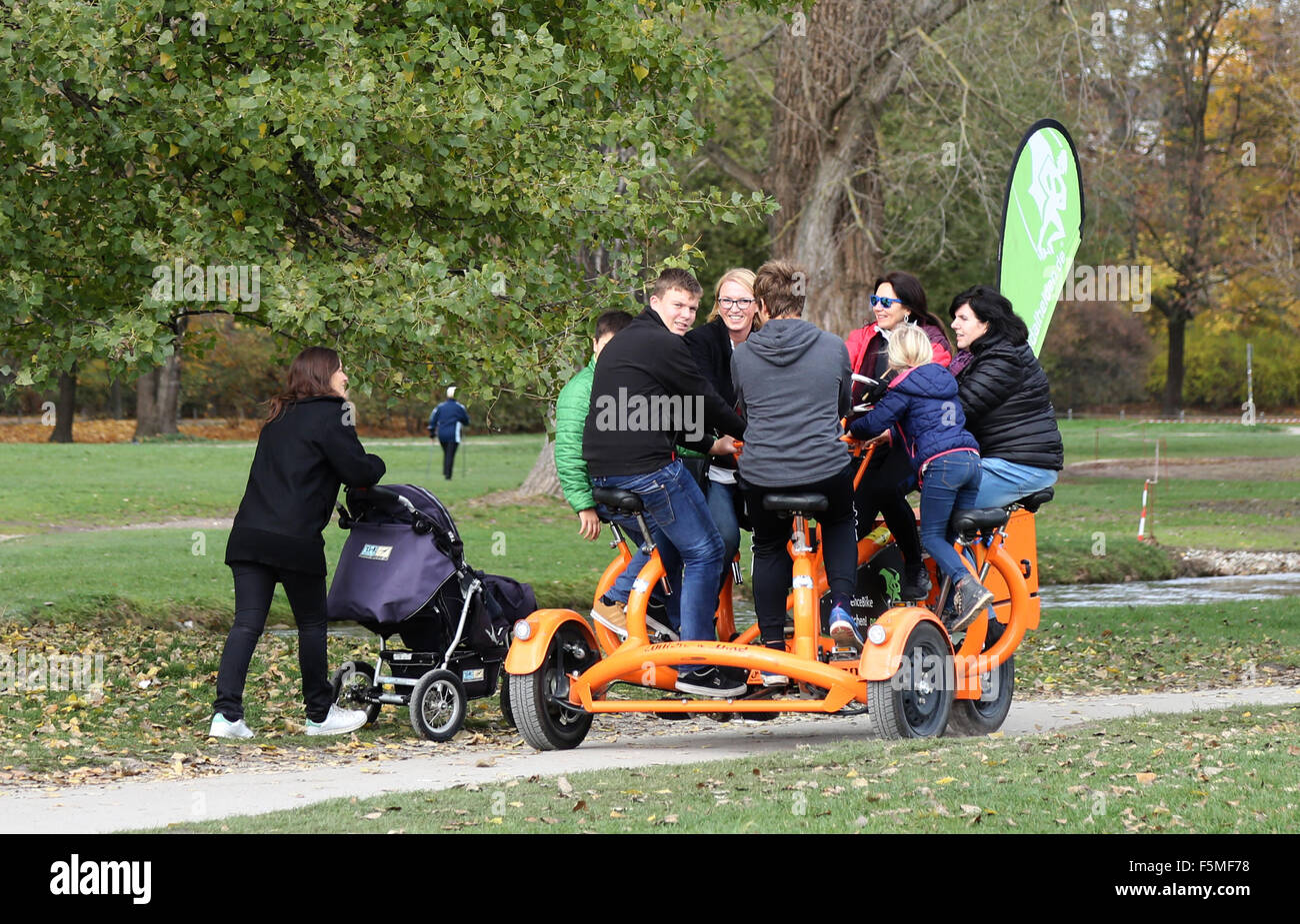 Un groupe familial équitation une étrange peddle powered défiler le parc Englischer Garten à Munich, Allemagne Banque D'Images