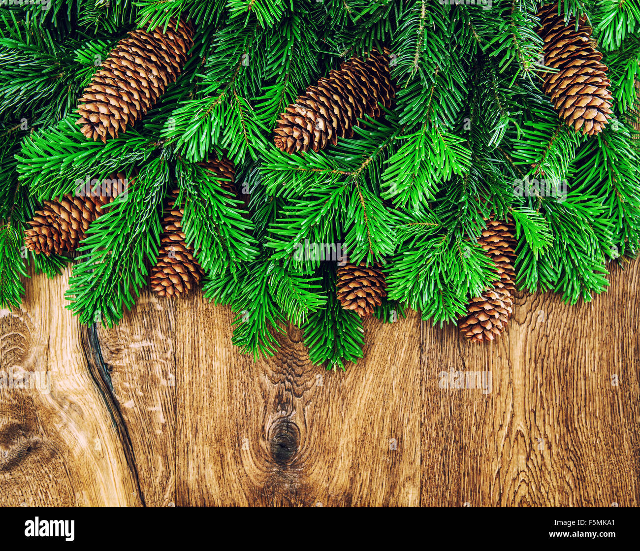 Les branches d'arbre de Noël avec les cônes sur fond de bois. Vacances d'hiver décoration Banque D'Images