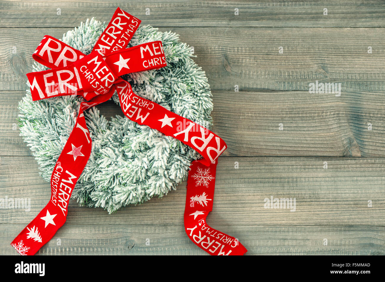 Couronne de Noël avec Red Ribbon bow sur fond de bois. Décoration de fête. Joyeux Noël ! Tons style vintage photo Banque D'Images