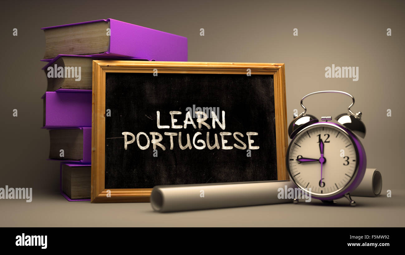 Apprendre le portugais - Chalkboard with Hand Drawn citation inspirante, pile de livres, Réveil et rouleaux de papier sur Bac floue Banque D'Images