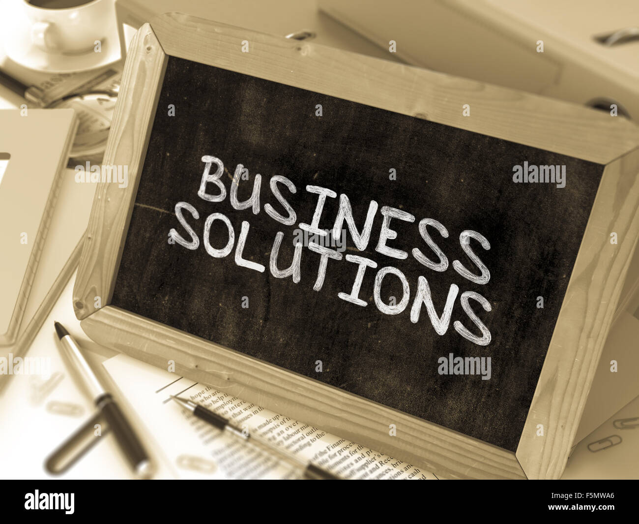 Business Solutions écrites de craie blanche sur un tableau noir. La composition avec petit tableau sur fond de table de travail Banque D'Images