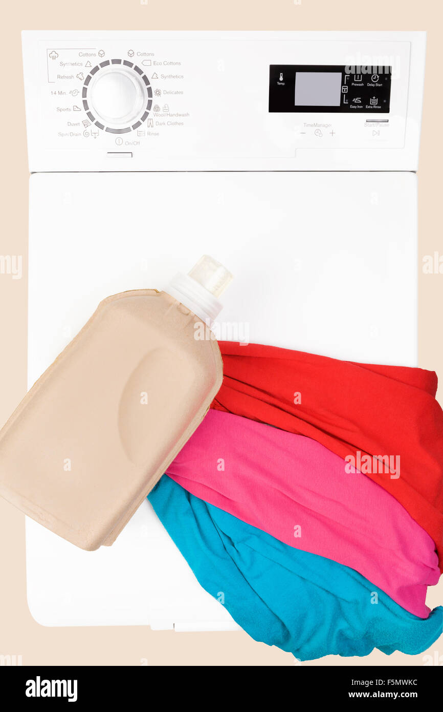 Arrière-plan de blanchisserie. Lave-linge à chargement par le haut avec les matières organiques naturelles du détergent et de l'habillement coloré vue d'en haut. Banque D'Images