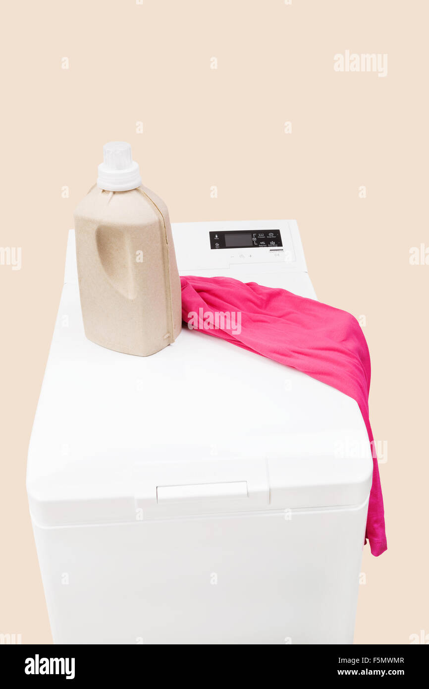 Arrière-plan de blanchisserie. Lave-linge à chargement par le haut avec du détergent et de matières organiques naturelles isolées aux vêtements. Banque D'Images