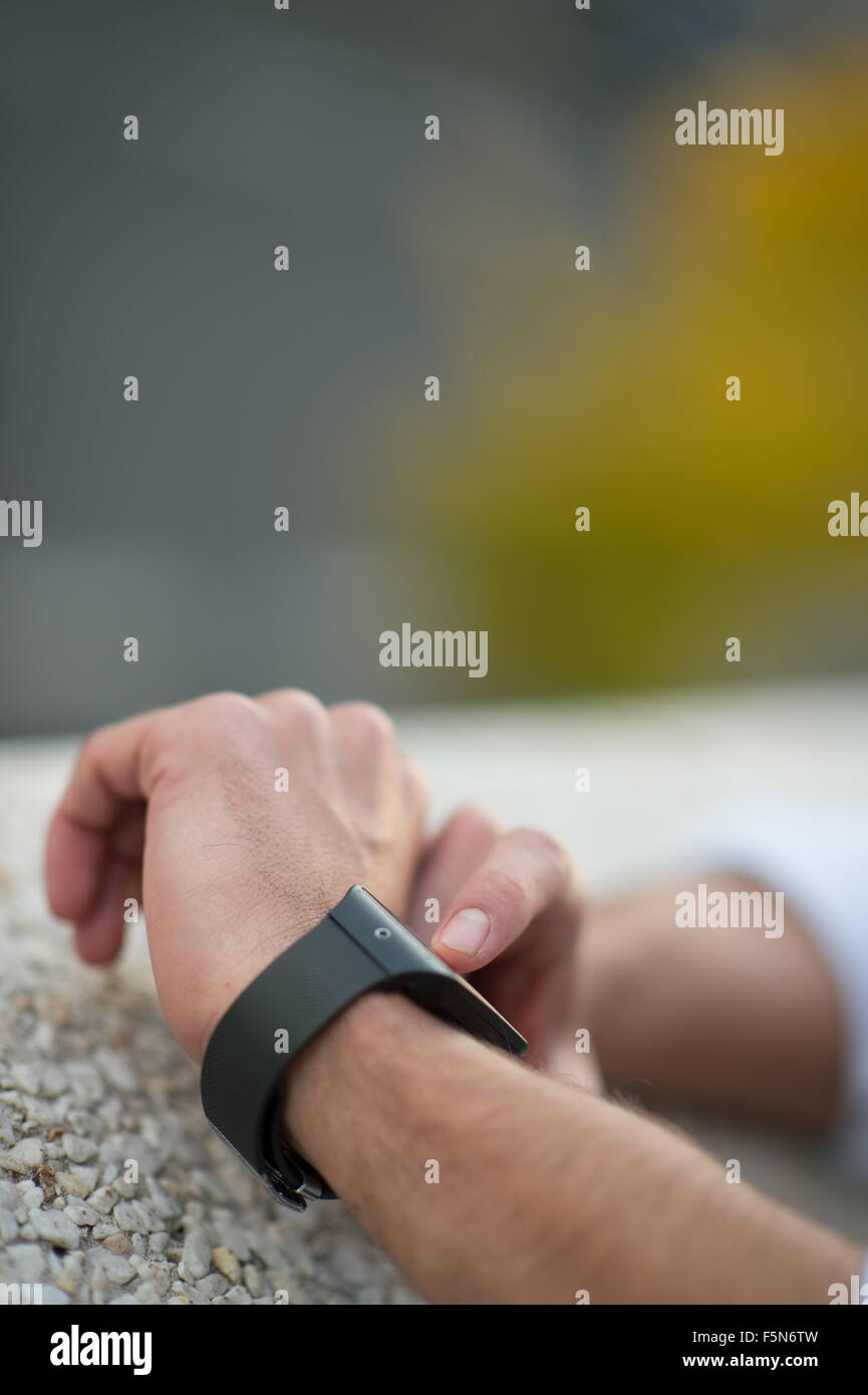 Homme avec un téléphone mobile connecté à un smart watch, close-up hands Banque D'Images