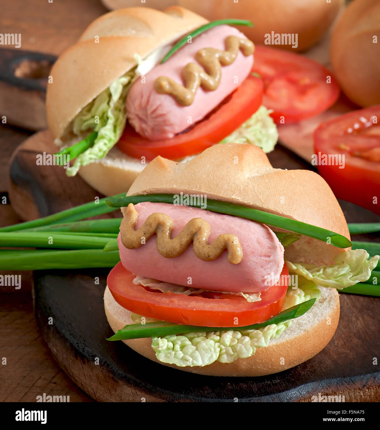 Peu joyeux hot dog avec de la saucisse et tomate Banque D'Images