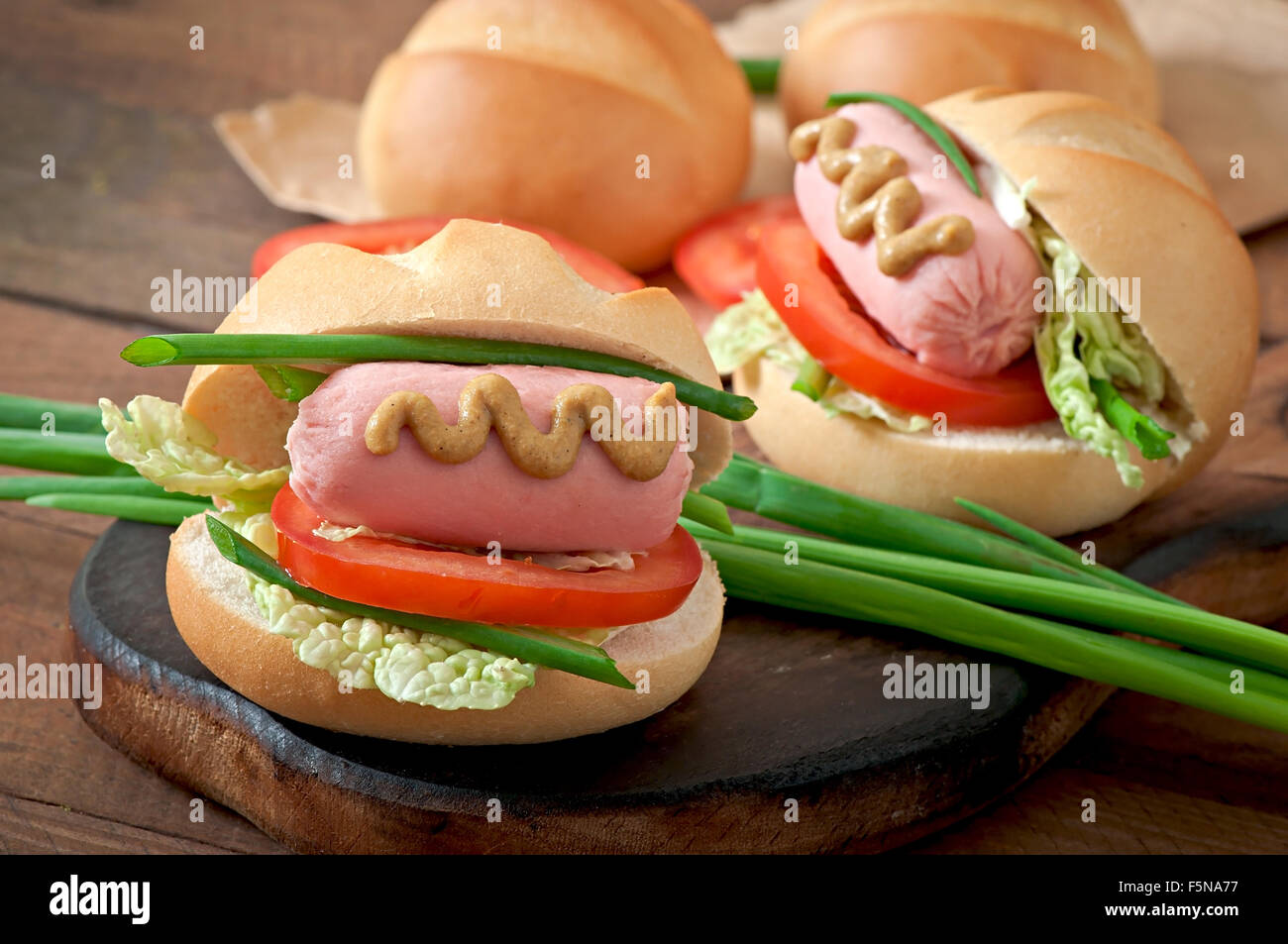 Peu joyeux hot dog avec de la saucisse et tomate Banque D'Images