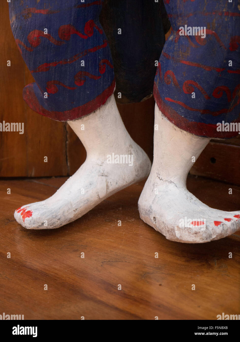 Pieds en bois thaïlandais avec des ongles peints en rouge montrant détouré peint sculpture presse à pantalons Banque D'Images