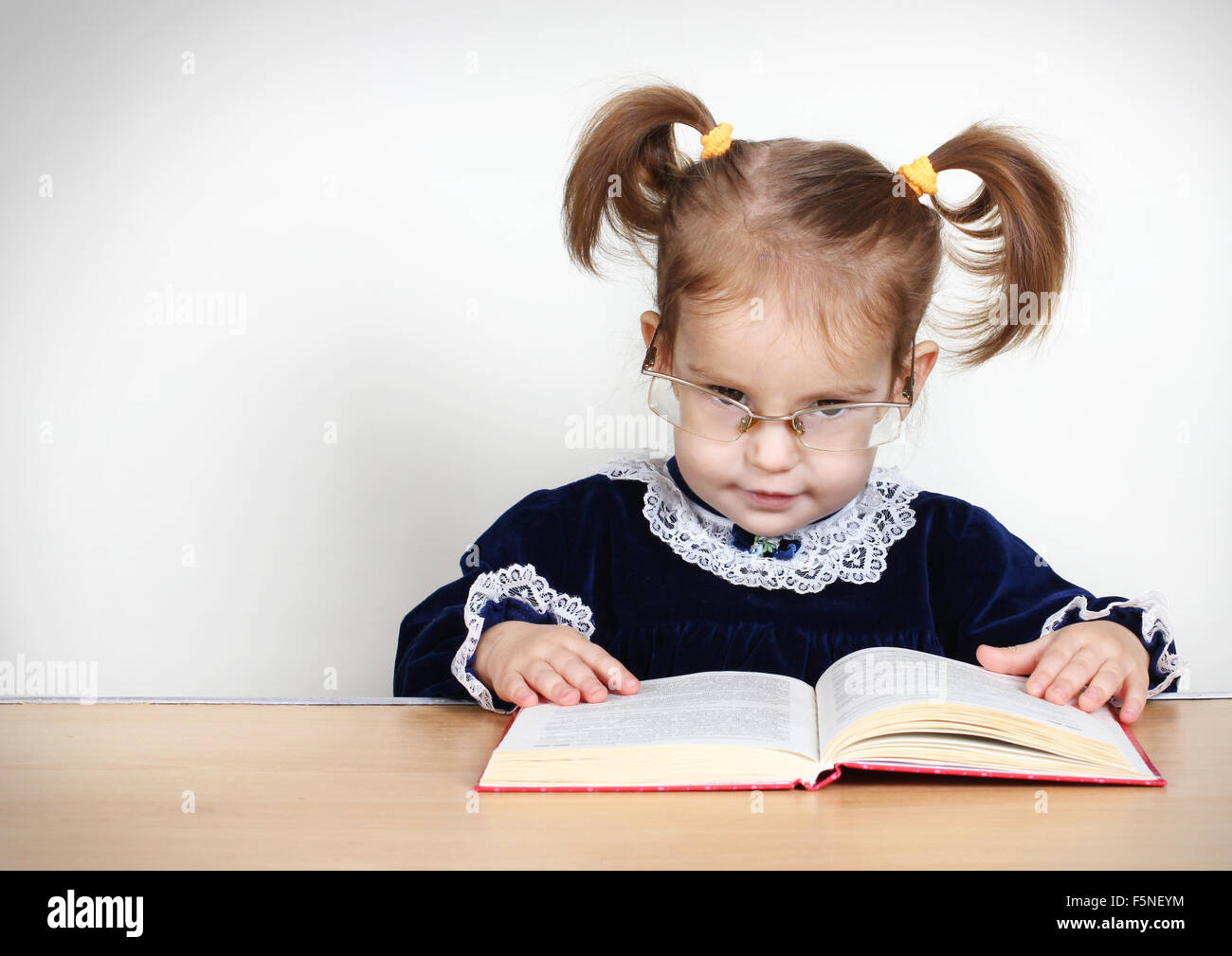 Funny little girl reading book Banque D'Images