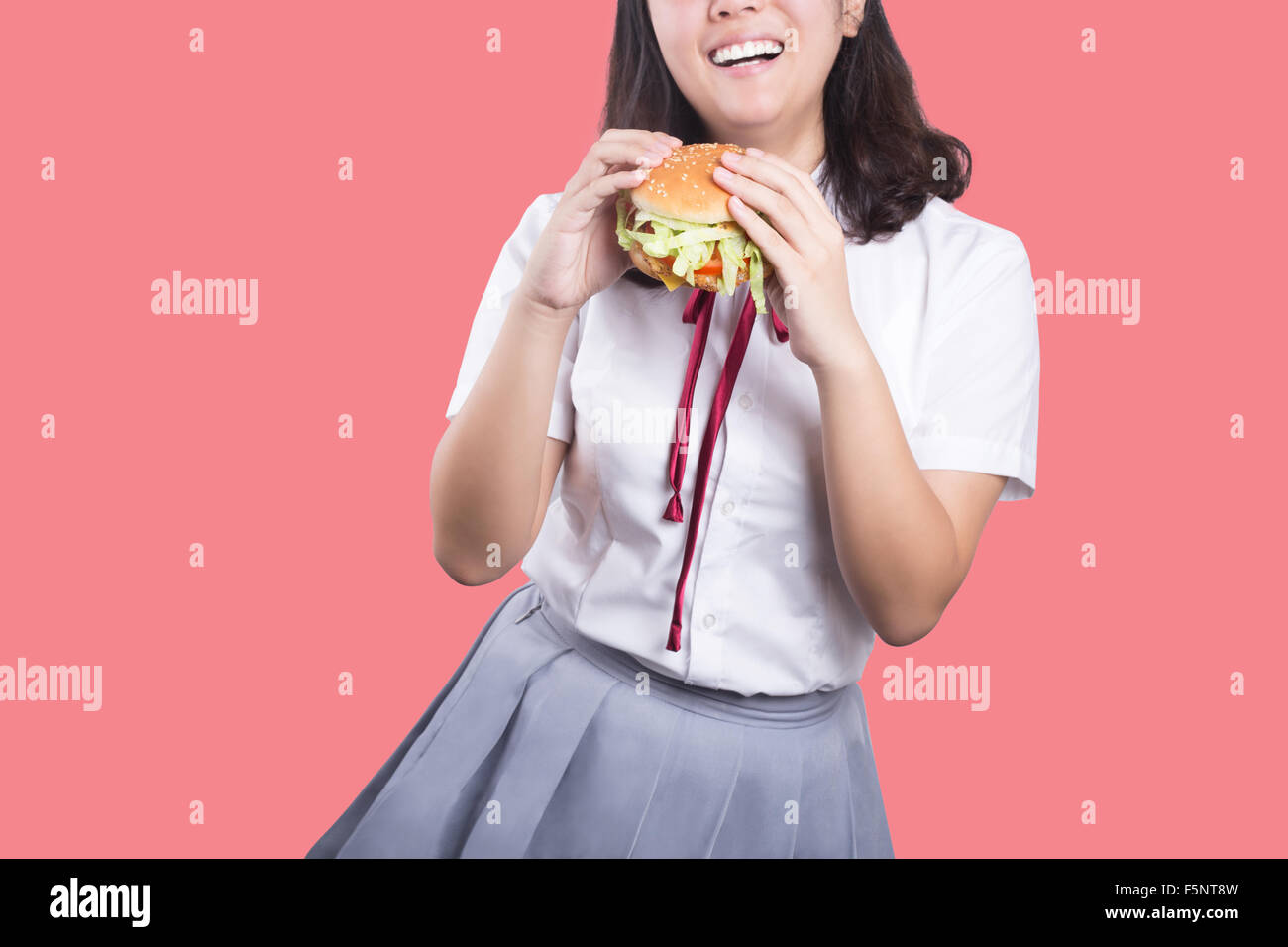 Asian girl eating hamburger Banque D'Images