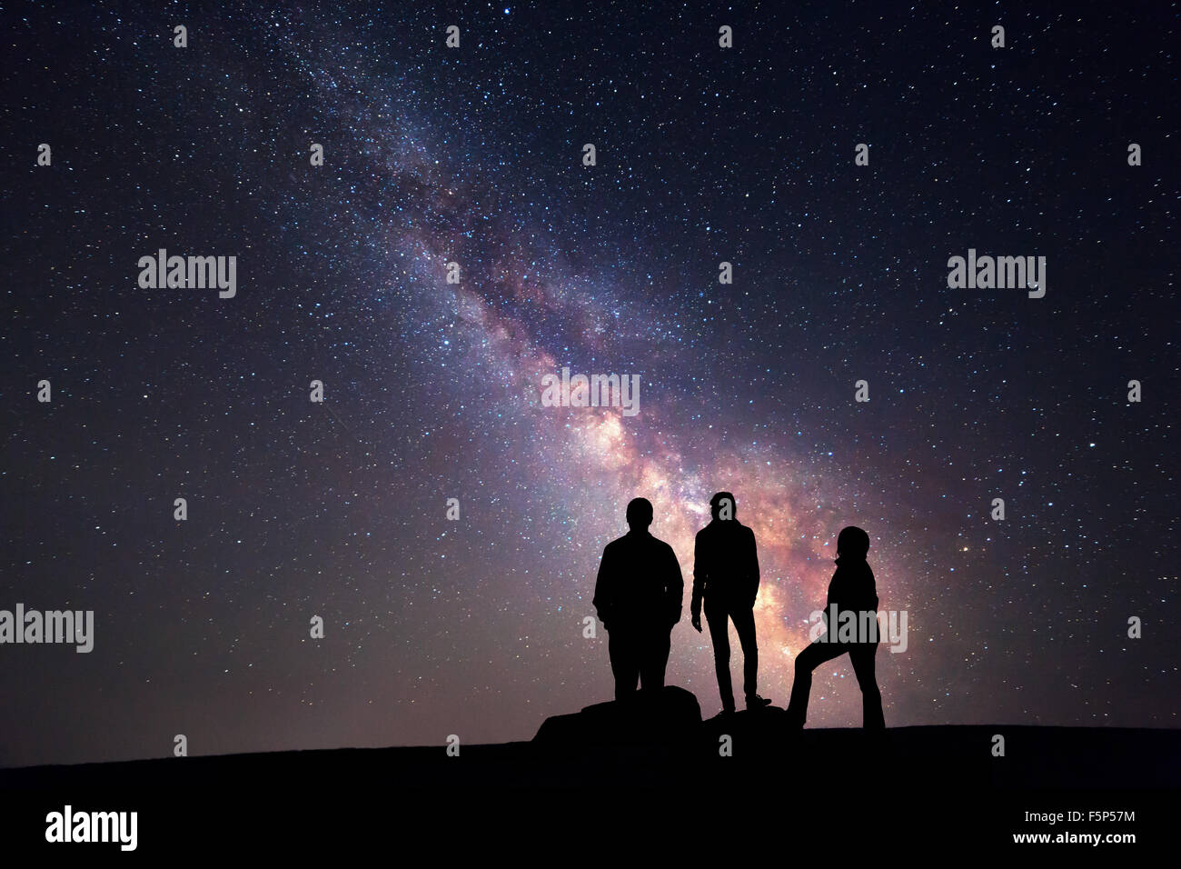 Voie lactée. Ciel de nuit avec des étoiles et silhouette d'une famille heureuse avec bras de Banque D'Images