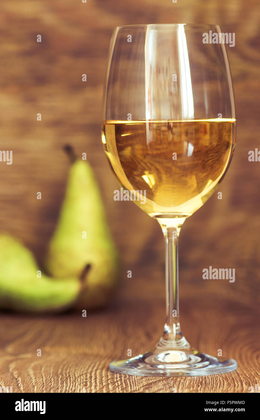 Verre de vin blanc Nature morte avec des poires sur fond de bois Banque D'Images