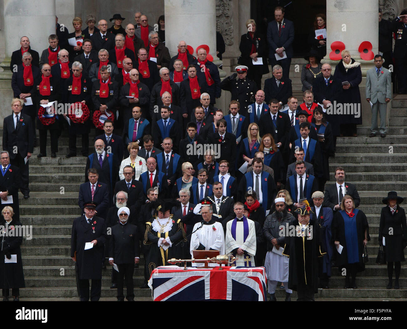 Portsmouth, Hampshire, Royaume-Uni. Nov 8, 2015. Portsmouth arrêté toujours en silence aujourd'hui pour marquer ceux qui sont tombés dans les guerres à travers le monde. Les foules se sont réunis à Guildhall Square pour rendre hommage à tous ceux qui ont servi dans les conflits à travers le monde. Des centaines de personnes se sont rendues à la place où la foule se tenait dans la réflexion sombre se souvenir de tous ceux qui se sont battus et sont morts pour leur pays. Des dirigeants communautaires, des représentants des forces armées, et des dirigeants de confiance tous les rejoint le service et déposé des couronnes pour ceux qui sont morts. Credit : UKNIPAlamy Live News Banque D'Images