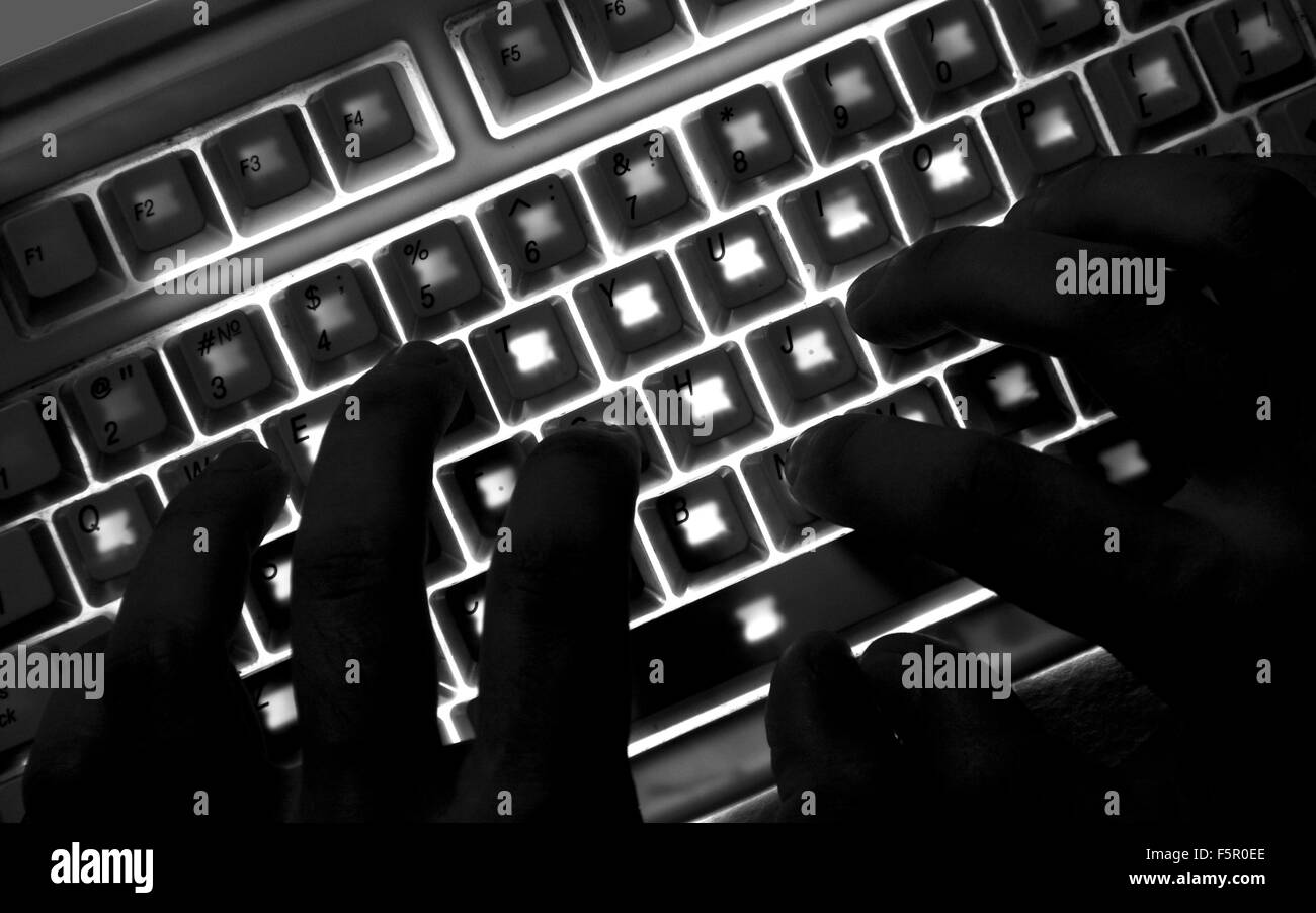 Silhouette de mains sur le clavier d'éclairage Banque D'Images