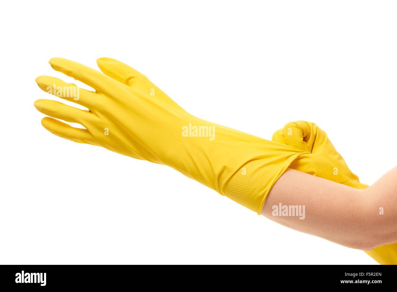 Les mains de mettre des gants en caoutchouc de protection jaune sur fond blanc contre Banque D'Images