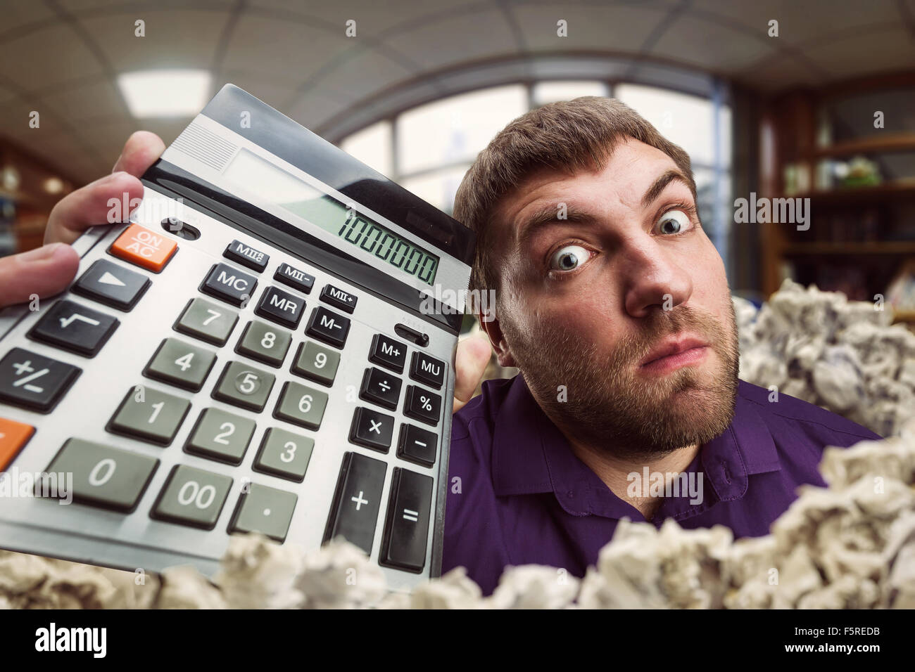 Surpris comptable détient une grande calculatrice avec total Banque D'Images