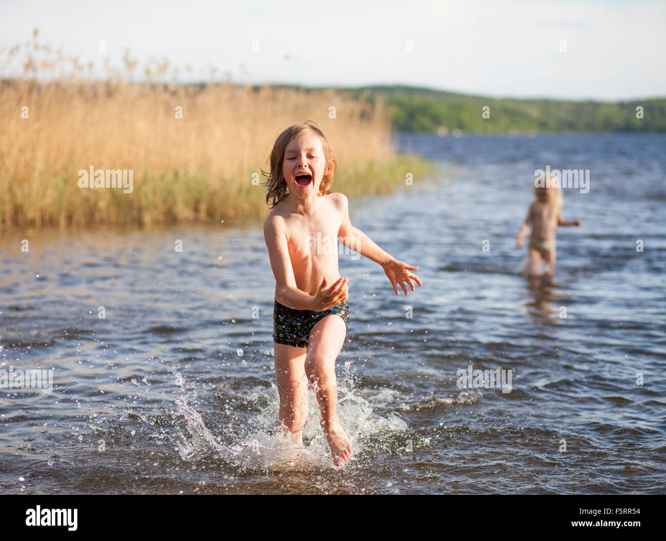 La Suède, Vastergotland, Lerum, lac Aspen, Boy (8-9) et (6-7) à l'affiche dans le lac Banque D'Images