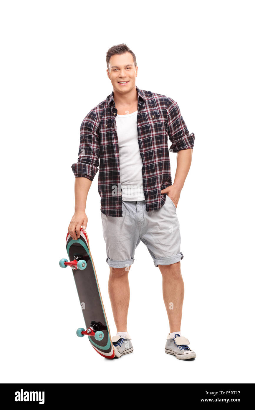 Portrait d'un jeune skater tenant un skateboard et regardant la caméra isolé sur fond blanc Banque D'Images