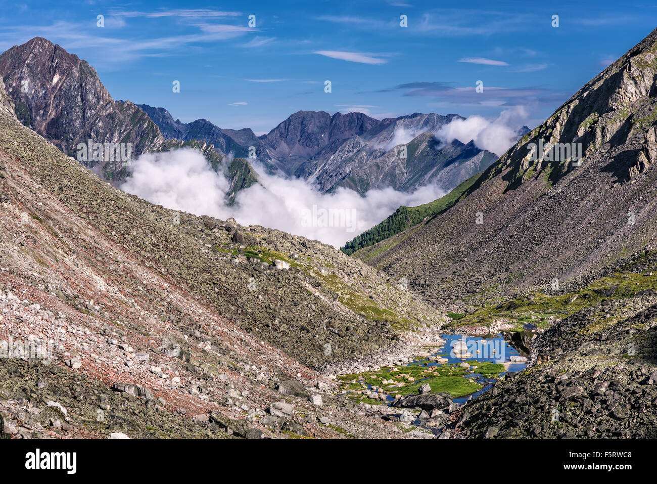 Les pentes des montagnes avec des talus en pierre et un petit lac au fond. Sayan de l'Est. La Bouriatie Banque D'Images