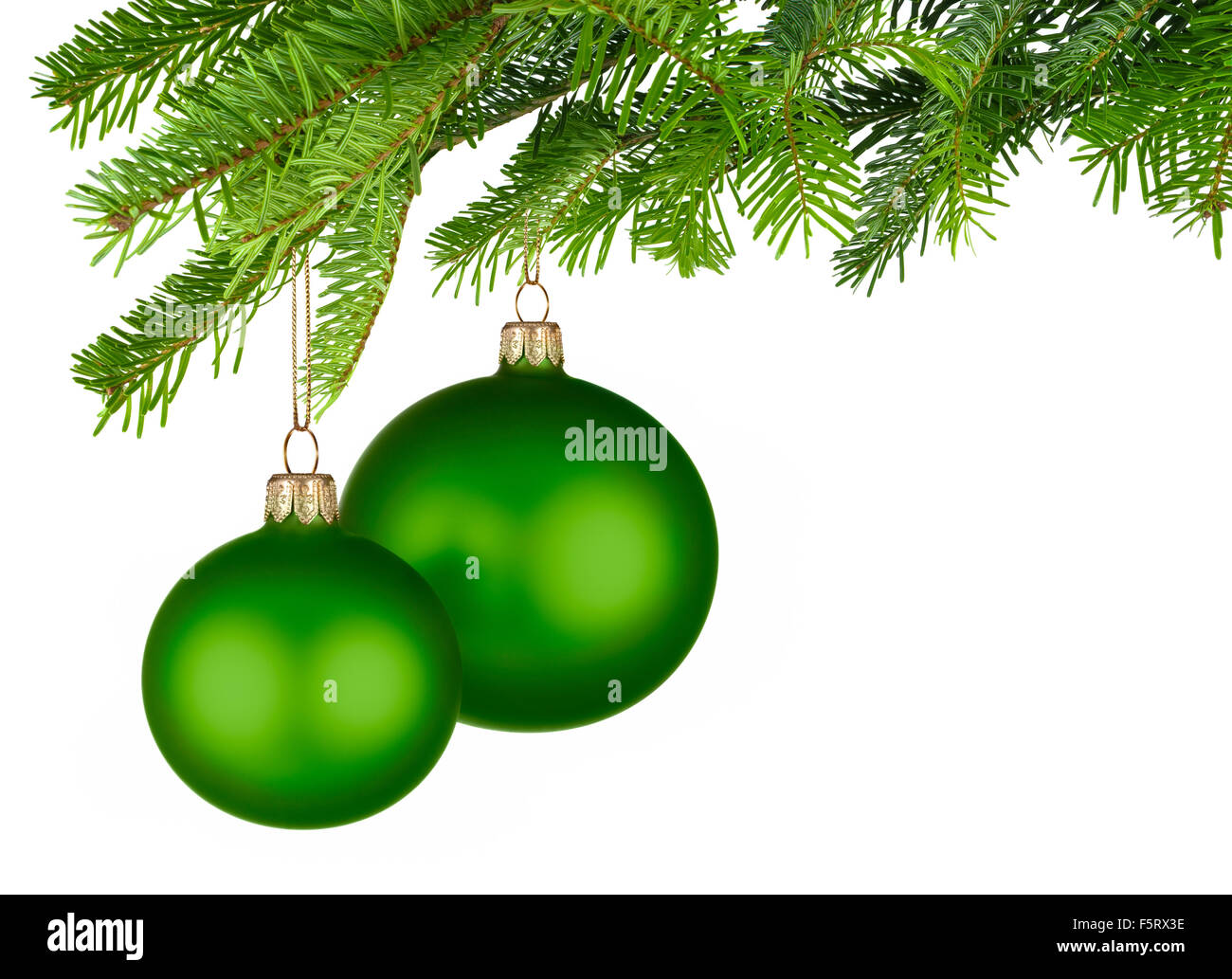 Studio lumineux tourné de deux boules de Noël vert isolés pendant de brindilles de sapin vert frais Banque D'Images